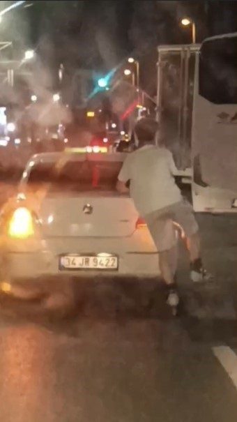 Aracın arkasına tutunarak ilerleyen patenli gencin tehlikeli